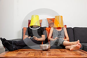 Young couple play video games sitting comfortably on the sofa at home