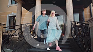 A young couple playfully descends the stairs.