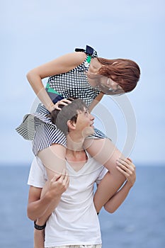 Young couple playing against sea in overcast day