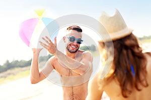 Young couple playing with a ball at the beach