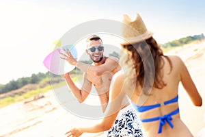 Young couple playing with a ball at the beach