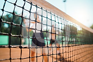 Young couple playing doubles tennis, selective focus at the net.