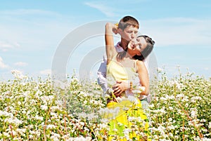 Young couple playing on field of flowers