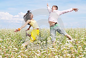 Young couple playing on field of flowers