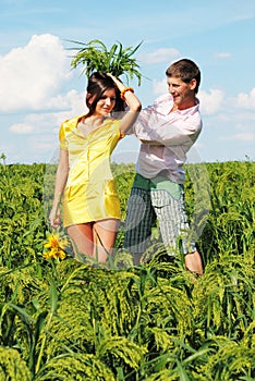 Young couple playing on field in sunny day