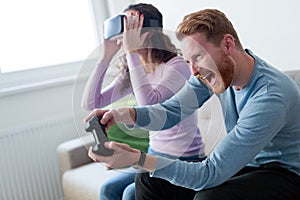 Young couple playing games with virtual reality headset