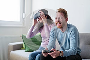 Young couple playing games with virtual reality headset