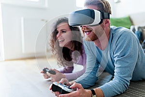 Young couple playing games with virtual reality headset