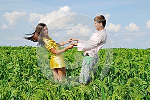 Young couple playing on green field