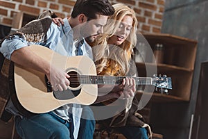 young couple playing guitar and singing together