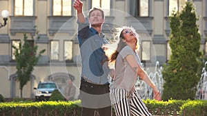 Young couple playing with a paper aeroplanes outdoors.