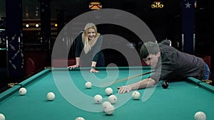 Young couple playing pool in a bar. Slow motion