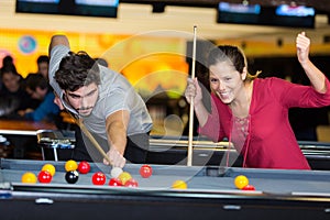 young couple playing pool woman winning