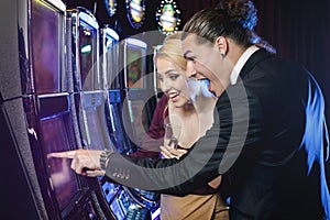 Young couple playing slot machines in the casino