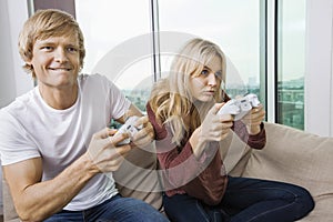 Young couple playing video game in living room at home