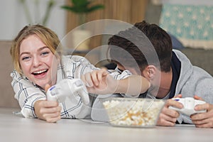 Young couple playing videogames at home