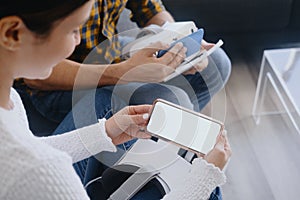 Young Couple Playing Virtual Reality With Headset On Sofa