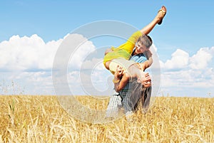 Young couple playing on wheat sunny field