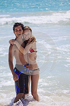 Young couple plays in the surf