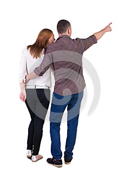 Young couple pointing.