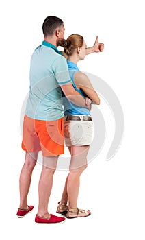 Young couple pointing at wal Back view