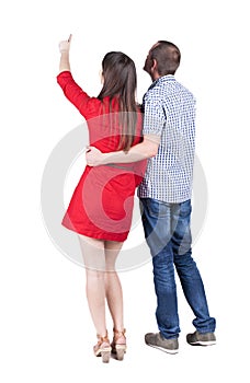 Young couple pointing at wal Back view