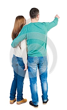 Young couple pointing at wal Back view