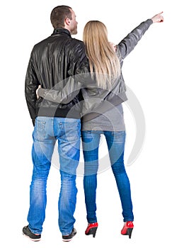 Young couple pointing at wal Back view (woman and man).