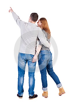 Young couple pointing at wal Back view (woman and man). .