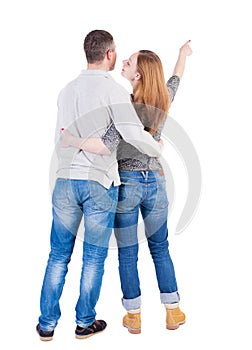 Young couple pointing at wal Back view (woman and man).