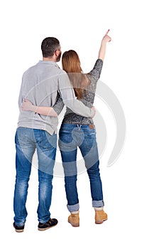 Young couple pointing at wal Back view (woman and man).