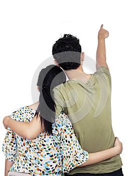 Young couple pointing at wall