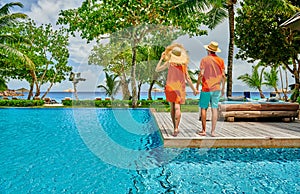 Young couple by poolside. Resort swimming pool at Seychelles