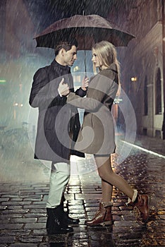 Young couple posing in heavy rain