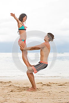 Young couple practice an exercise in trust on a tropical beach