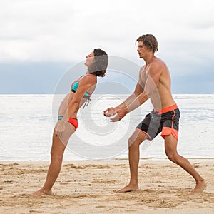 Young couple practice an exercise in trust on a tropical beach