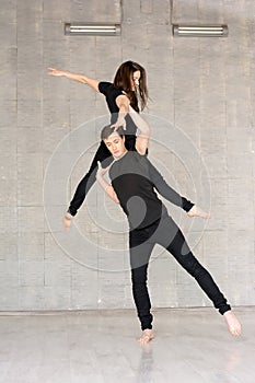 Young couple practices acrobatic balance.