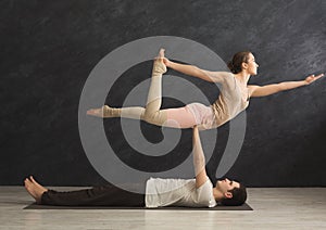 Young couple practicing acroyoga on mat together