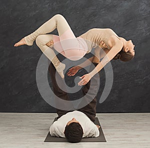 Young couple practicing acroyoga on mat together