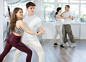 Young couple practicing passionate samba in dance class