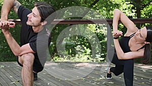 Young couple practicing revolved lunge yoga pose