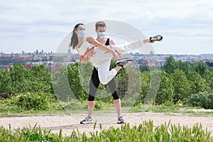 Young couple practicing street dance at a park wearing protective face masks