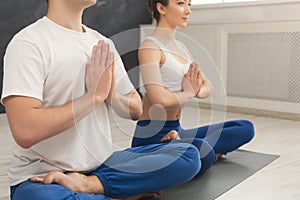 Young couple practicing yoga sitting in padmasana