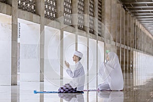 Young couple prays to the Allah after doing Salat