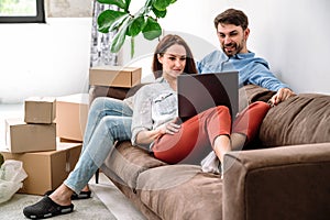 Young couple prepare to relocation and search moving service on laptop