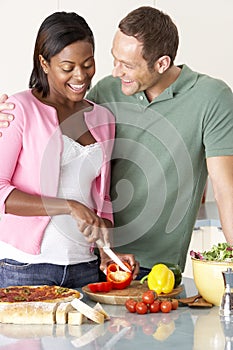 Young Couple Preparing Meal In Kitchen