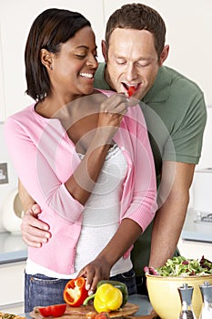 Young Couple Preparing Meal In Kitchen