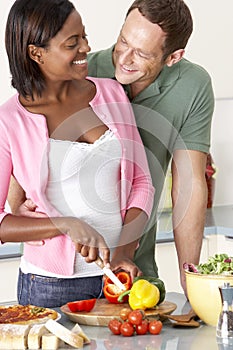 Young Couple Preparing Meal In Kitchen