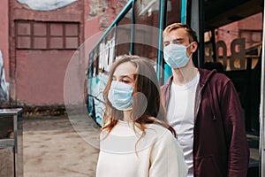 Young couple in protective masks walk down deserted city streets