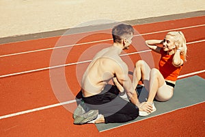 Young couple pump abdominal muscles on yoga mat